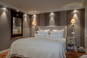 Schlafzimmer mit einem großen weißen Bett und einem Spiegel in der Unterkunft Ferienwohnung Sönshörn in Munkmarsch