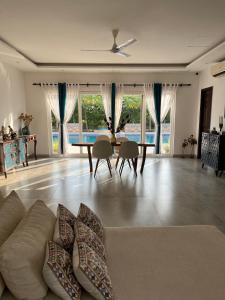 a living room with a couch and a table at Luxurious Farmhouse with Pool outside Delhi in Noida