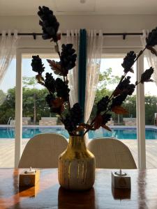 a vase with flowers in it sitting on a table at Luxurious Farmhouse with Pool outside Delhi in Noida