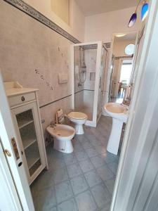 ein Badezimmer mit zwei Waschbecken, einem WC und einer Dusche in der Unterkunft Aqua Blu Apartment Stella Maris in Piano di Sorrento