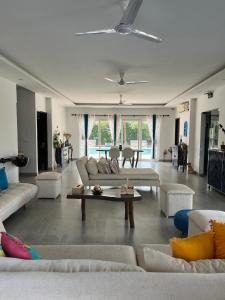 a large living room with couches and a table at Luxurious Farmhouse with Pool outside Delhi in Noida