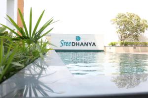 a swimming pool with a sign in the background at Sree Dhanya Vantage point in Trivandrum