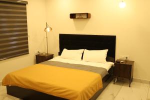 a bedroom with a large bed with a yellow blanket at Sree Dhanya Vantage point in Trivandrum