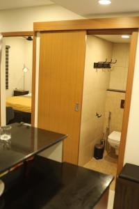 a bathroom with a toilet and a room with a bed at Sree Dhanya Vantage point in Trivandrum