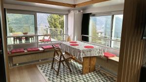 Camera con tavolo e balcone con finestre. di Bellavista Marilleva 1400 - Val di Sole a Marilleva