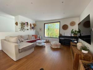 un soggiorno con un divano e un tavolo di Villa avec piscine 3 chambres a Foix