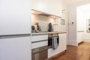 a kitchen with white cabinets and a stove at Stylish Studio near the City Centre in Sydney