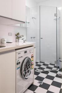 a washing machine in a kitchen with a black and white floor at Stylish Studio near the City Centre in Sydney