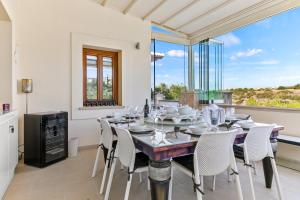 a dining room with a table and chairs and a window at 3 bedroom Villa Eleyjo with stunning private pool, Aphrodite Hills Resort in Kouklia