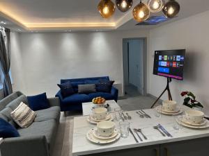 een woonkamer met een tafel en een televisie bij Luxury 2 Bed Apartment in Royal Sutton Coldfield in Sutton Coldfield