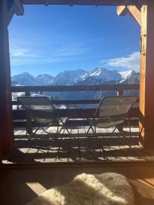 a balcony with chairs and a table and a view of mountains at Chalet le Villarais1 sauna billard in Villard-Reculas