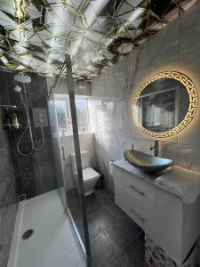 a bathroom with a sink and a shower and a mirror at Luxury 2 Bed Apartment in Royal Sutton Coldfield in Sutton Coldfield