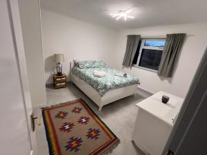 Schlafzimmer mit einem Bett, einem Fenster und einem Teppich in der Unterkunft Luxury 2 Bed Apartment in Royal Sutton Coldfield in Sutton Coldfield