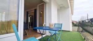 una mesa azul y sillas en el balcón en Le Bel Horizon, en Bessines