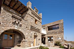 an old stone building with a wooden door at Tinos Habitart in Triandáros