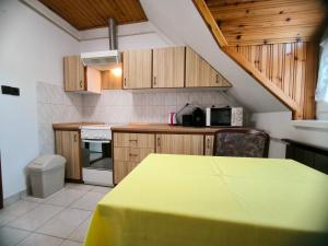 a kitchen with a table with a yellow table cloth at Oleander Vendégház in Tihany