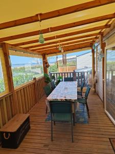 una terraza de madera con mesa y sillas. en Mobil home 3 chambres avec vue sur l'étang - 4* en Canet-en-Roussillon