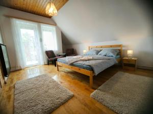 a bedroom with a bed and two rugs at Oleander Vendégház in Tihany