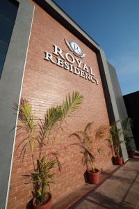 a sign on the side of a building with plants at ROYAL RESIDENCY in Kānnangād