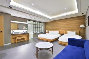 a hotel room with two beds and a couch at Seomyeon IB Hotel in Busan