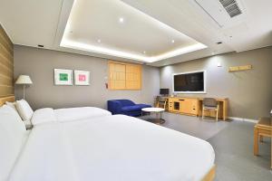 um quarto de hotel com uma cama e uma televisão de ecrã plano em Seomyeon IB Hotel em Busan