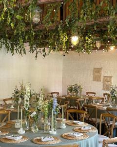 une salle à manger avec des tables, des chaises et des plantes dans l'établissement Villa Rata, à Ratnyčia