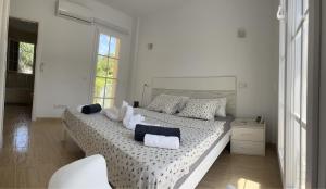 um quarto branco com uma cama grande e almofadas em La Esperanza em Cala Murada