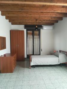 1 dormitorio con cama y techo de madera en Il balcone sulla piazza, en Gela