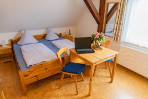 a bedroom with a bed with a laptop on a desk at Ferienhof Hofer in Absberg