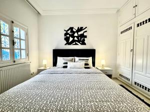 a bedroom with a large bed and two windows at COSY Apartment in Sidi Bou Said Village in Sidi Bou Saïd