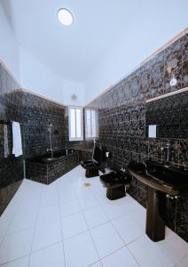 ein Badezimmer mit 3 Waschbecken und 3 WCs in der Unterkunft ST Beach Villa in Kibweni