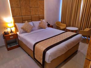 ein Schlafzimmer mit einem großen Bett in einem Hotelzimmer in der Unterkunft ROYAL RESIDENCY in Kānnangād
