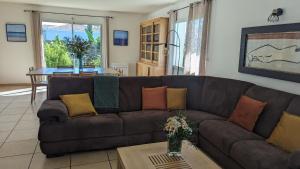 Una sala de estar con un sofá marrón y una mesa. en Villa Naturéa, en Messanges