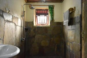 ein Bad mit einem Waschbecken und einem Fenster in der Unterkunft Room in BB - Red Rocks Rwanda - Triple Room in Nyakinama