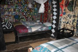 ein Schlafzimmer mit einem Bett und einer farbenfrohen Wand in der Unterkunft Room in BB - Red Rocks Rwanda - Triple Room in Nyakinama
