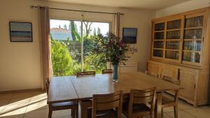 Un comedor con una mesa y un gran ventanal. en Villa Naturéa, en Messanges