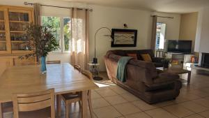 Una sala de estar con una mesa de madera y un sofá. en Villa Naturéa, en Messanges