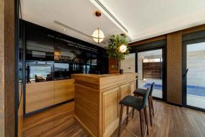 een keuken met een bar met 2 stoelen en ramen bij MonteLux Mansion in Tivat