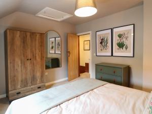 a bedroom with a large bed and a mirror at The Loft at The Old Dog Thorpe in Ashbourne