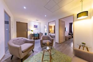 a living room with two chairs and a couch and a table at Hôtel Princes de Catalogne in Collioure