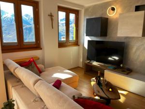 sala de estar con sofá y TV de pantalla plana en Jacuzzi mountain view appartment, en Cassina Valsassina