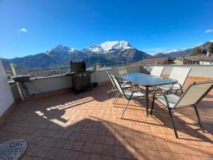 una mesa y sillas en un balcón con montañas en Jacuzzi mountain view appartment, en Cassina Valsassina