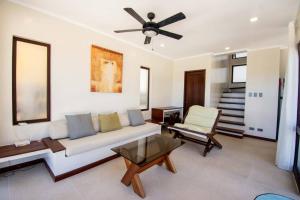 a living room with a couch and a ceiling fan at Hey Jude Bulabog Beachfront Residence in Boracay