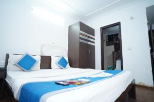 ein Schlafzimmer mit einem großen weißen Bett mit blauen Kissen in der Unterkunft Hotel Laxmi Villa Palace in Jaipur