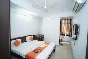 Schlafzimmer mit einem Bett und einem Deckenventilator in der Unterkunft Hotel Laxmi Villa Palace in Jaipur