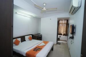 ein Hotelzimmer mit einem Bett und einem TV in der Unterkunft Hotel Laxmi Villa Palace in Jaipur