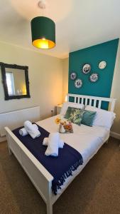 a bedroom with a large bed with plates on the wall at Worthingtons by Spires Accommodation A cosy and comfortable home from home place to stay in Burton-upon-Trent in Burton upon Trent