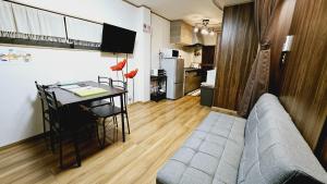 uma sala de estar com uma mesa e um sofá e uma cozinha em Kyoto - Apartment - Vacation STAY 98413v em Quioto