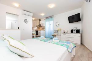 una camera bianca con letto e TV di Wonderful House Sandra a Mali Lošinj (Lussinpiccolo)