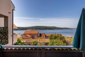 einen Balkon mit Blick auf die Stadt und das Wasser in der Unterkunft Wonderful House Sandra in Mali Lošinj